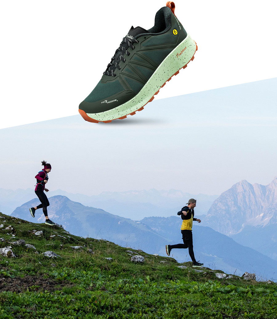 Closeup des Joe Nimble Trail Addict Pro-R Traillaufschuh in Basil/Grün mit Trailläufern in den Bergen