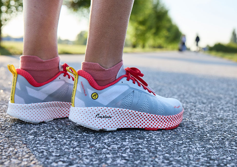 Der Joe Nimble Addict Pro-R Laufschuh in grau-rot auf der Straße