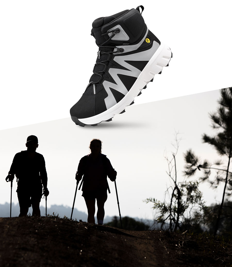 closeup des Joe Nimble Mountain Addict Wanderschuhs in Schwarz/weiß mit zwei Läufern bei Sonnenuntergang