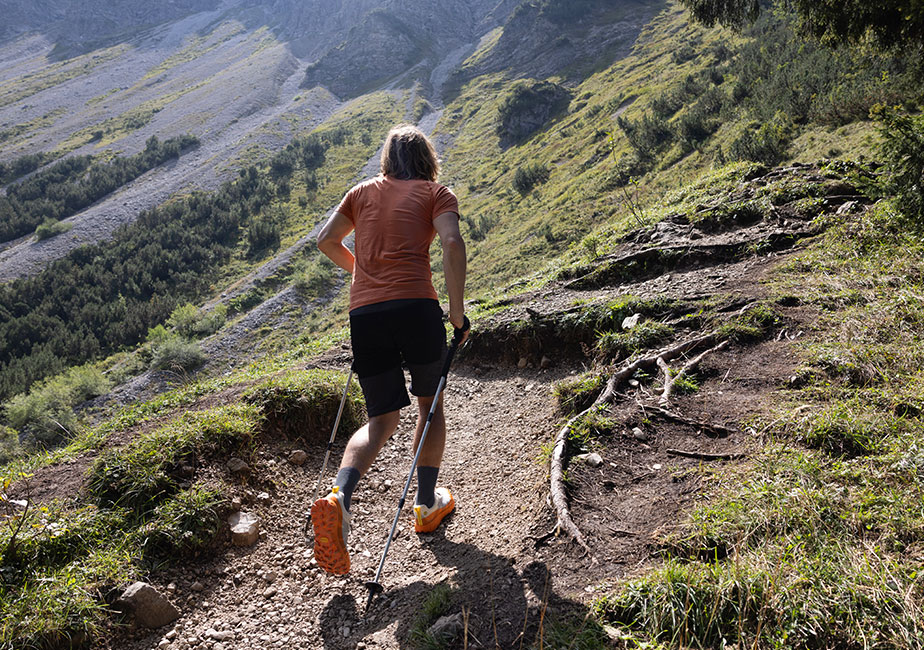 Läufer mit dem Joe Nimble Explore Addict Trailschuh in Orange im Gelände