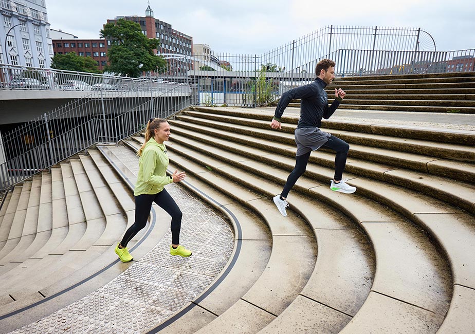 Läufer beim Lauftraining auf einer Treppe mit dem Joe Nimble Addict Pro-R Laufschuh in Gelb und Weiß