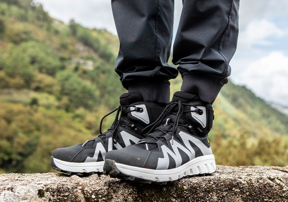 Der Joe Nimble Mountain Addict Wanderschuh in schwarz/weiß von der Seite in den Bergen